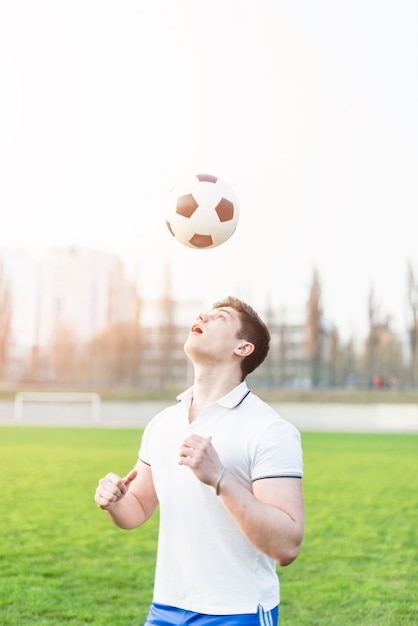 Fußballspieler, der Ball über Kopf wirft