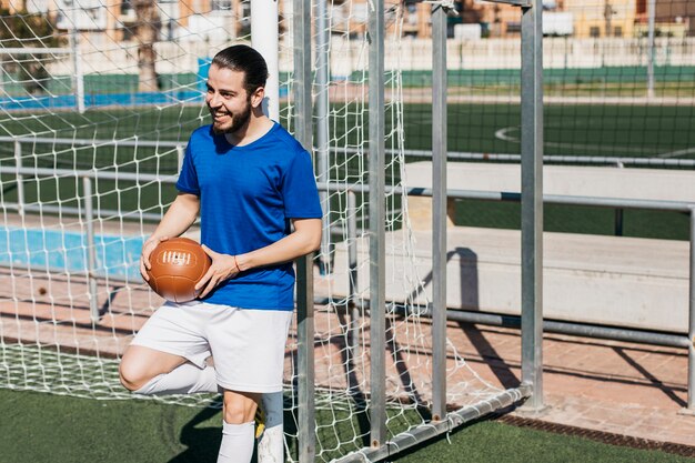 Fußballspieler, der gegen Pfosten sich lehnt