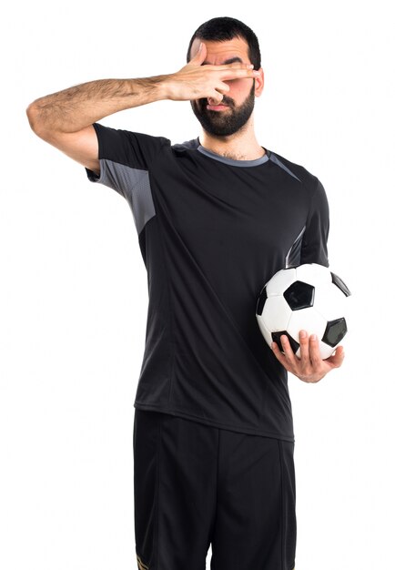 Fußballspieler, der seine Augen bedeckt