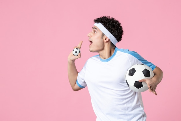 Fußballspieler der Vorderansicht in der Sportkleidung mit Ball