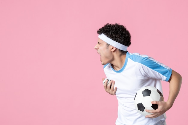 Kostenloses Foto fußballspieler der vorderansicht in der sportkleidung mit ball