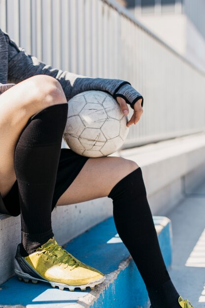 Fußballspieler mit Ball auf Bank