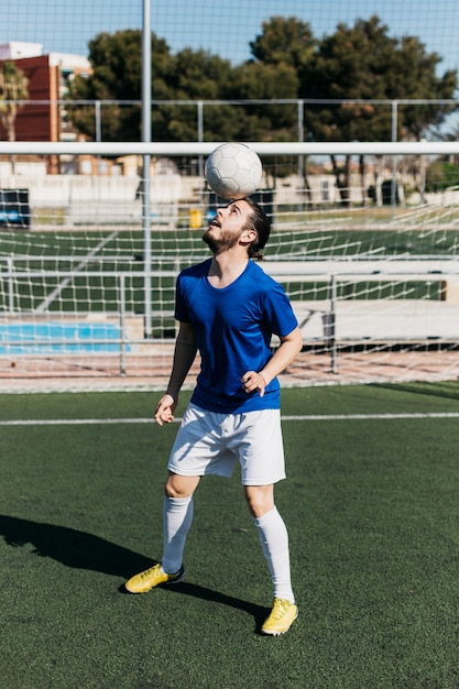 Fußballspieler mit Ball auf Kopf