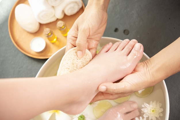 Fußwaschung im Spa vor der Behandlung. Spa-Behandlung und Produkt für weibliche Füße und Hand Spa.