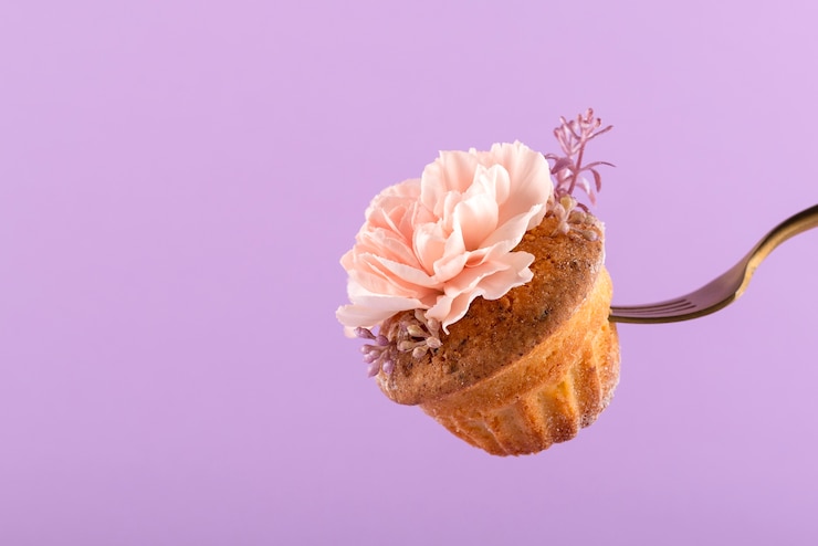 Kostenlose Foto gabel, die kleinen kuchen mit blume hält