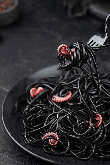 Gabel mit schwarzen Spaghetti und Tintenfisch