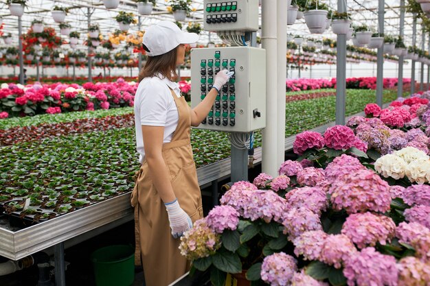 Gärtnerin mit moderner Ausrüstung zum Gießen von Blumen