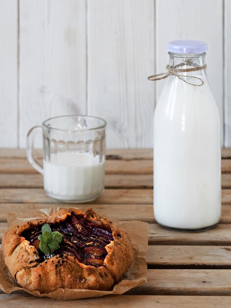 Galette mit Pflaumen und Flasche mit Milch