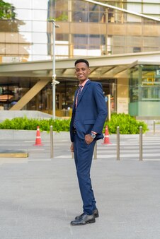 Ganzaufnahme eines erfolgreichen jungen afrikanischen geschäftsmannes in anzug und krawatte