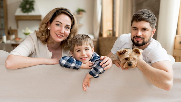 Ganze Familie mit Hund sitzt auf der Couch