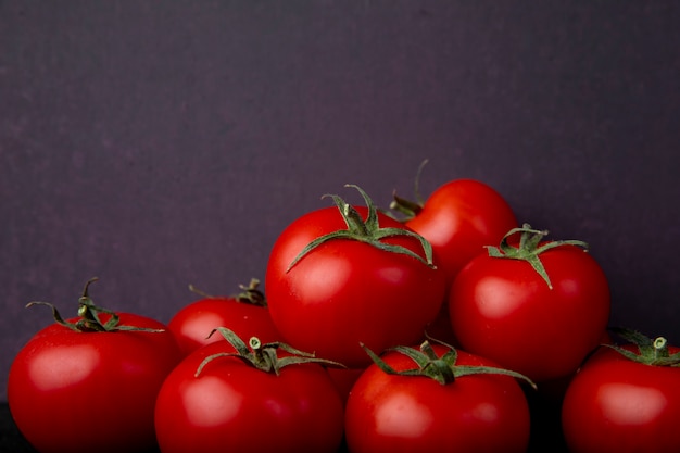 Ganze Tomaten auf lila Oberfläche