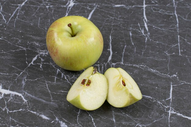 Ganze und geschnittene Äpfel auf Marmor.