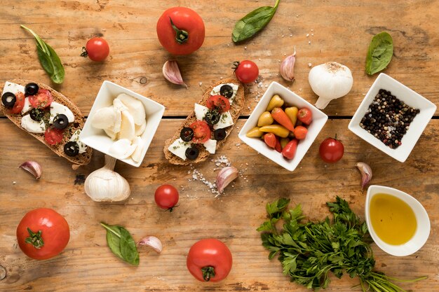 Garnieren Sie Bruschetta und frischen Bestandteil für das Kochen auf brauner Tabelle