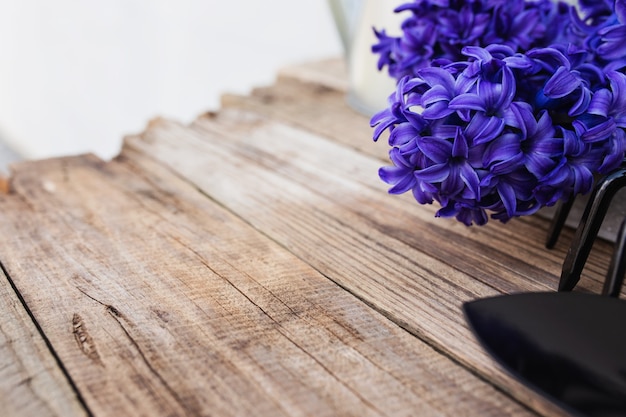Garten-hobby-konzept. blauviolette hyazinthenblüte, kleine gartenheugabel oder rechen und schaufel auf altem holztischhintergrund