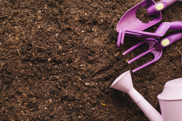 Kostenloses Foto gartenarbeit mit schaufel, gießkanne und platz auf der linken seite