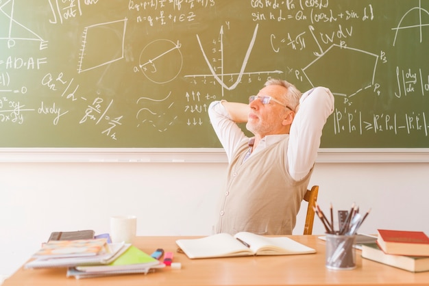 Gealterter Professor, der im Klassenzimmer sich entspannt