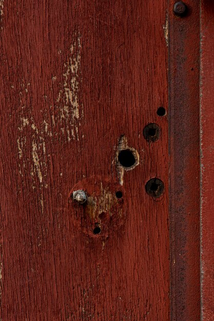 Gealtertes Holz mit Löchern und rostigem Metall