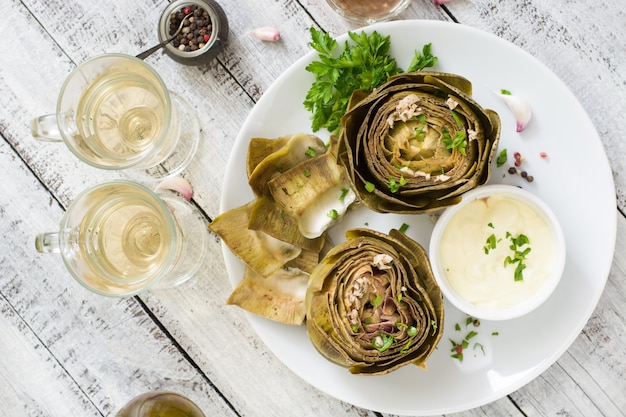 Gebackene artischocken gekocht mit knoblauchsauce, senf und petersilie. draufsicht