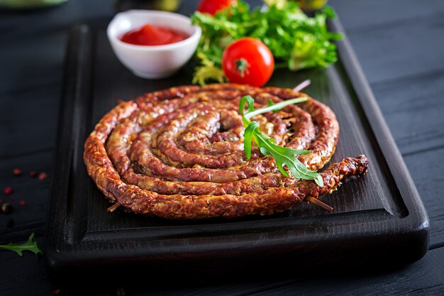 Gebackene hausgemachte Wurst auf einem Holzbrett.