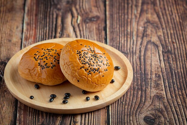 gebackene schwarze Bohnenpastenbrötchen auf dunklen Boden legen