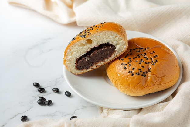 gebackene schwarze Bohnenpastenbrötchen auf weiße Schüssel setzen