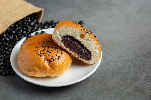 gebackene schwarze Bohnenpastenbrötchen auf weißem Teller