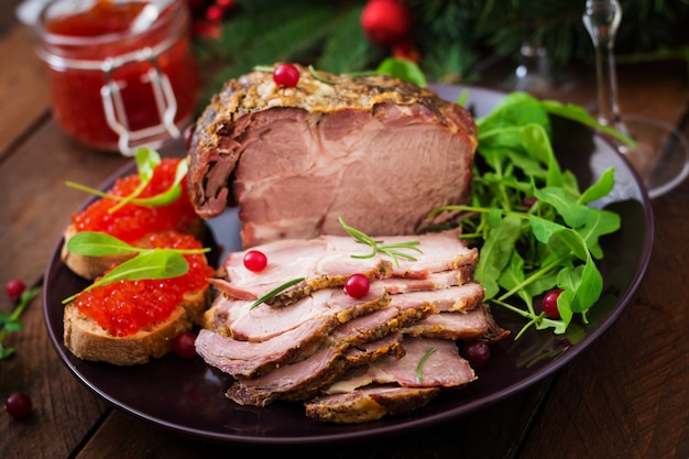 gebackener Schinken und roter Kaviar, serviert auf einem alten Holztisch.