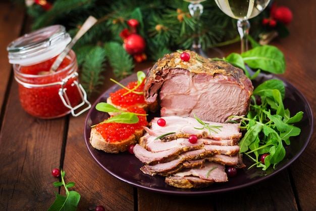 gebackener Schinken und roter Kaviar, serviert auf einem alten Holztisch.