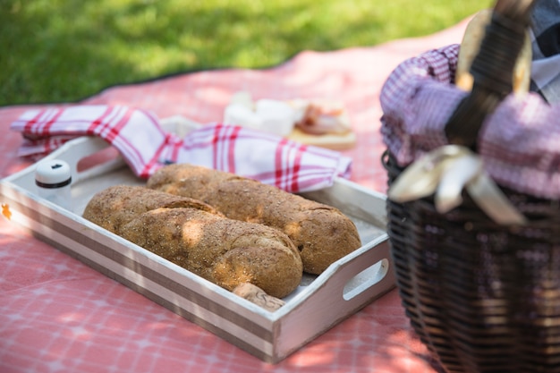 Gebackenes Brot im Behälter mit Korb auf Stoff