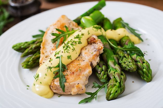 Kostenloses Foto gebackenes hähnchen, garniert mit spargel und kräutern