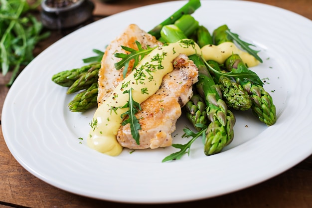 Gebackenes Hähnchen, garniert mit Spargel und Kräutern