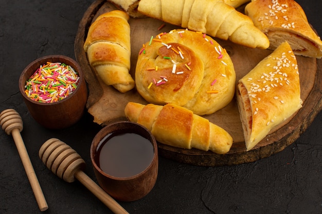 Gebäck und Croissants von oben auf dem braunen Schreibtisch und dem dunklen Boden