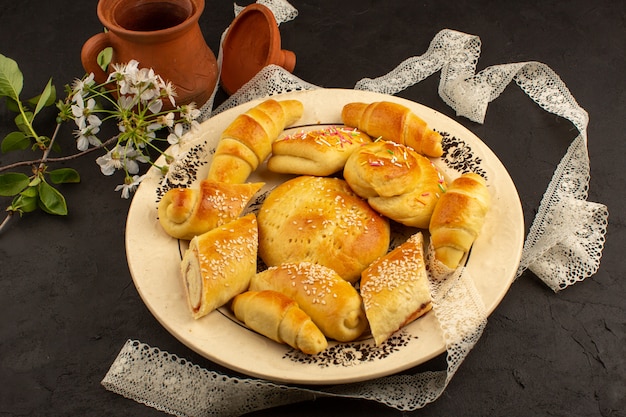 Kostenloses Foto gebäck und croissants von oben in der weißen platte im dunkeln