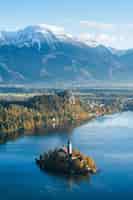 Kostenloses Foto gebäude auf einer kleinen insel in bled, slowenien, umgeben von hohen bergen