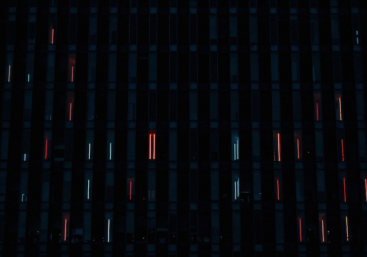 Kostenlose Foto gebäude in der nacht mit fenstern, die mit roten und weißen lichtern beleuchtet sind