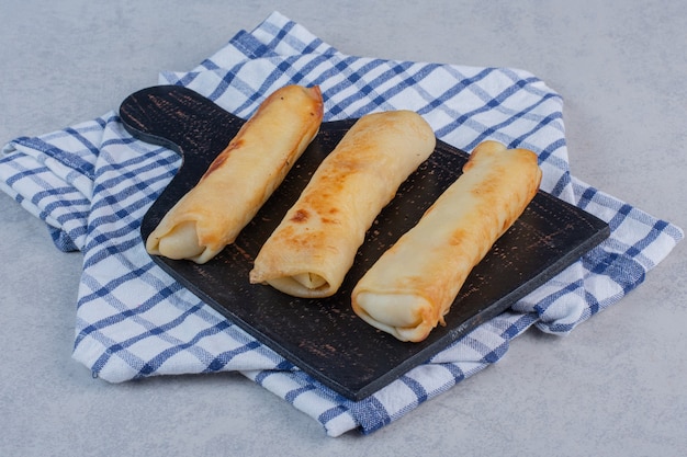 Gebratene Brötchen mit Käse auf Tafel.