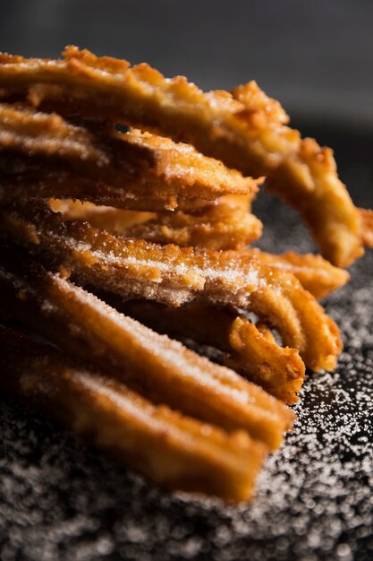 Gebratene Churros und Zucker der Nahaufnahme Vorderansicht