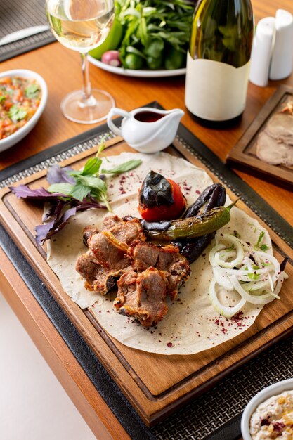 Gebratene Fleischknochen von oben mit gebratenem Gemüse, Weißwein und Soße auf dem Tisch Essen Mahlzeit Abendessen Restaurant