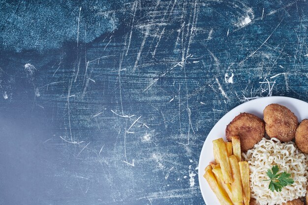 Gebratene Hähnchenschenkel mit Kartoffeln und Nudeln.