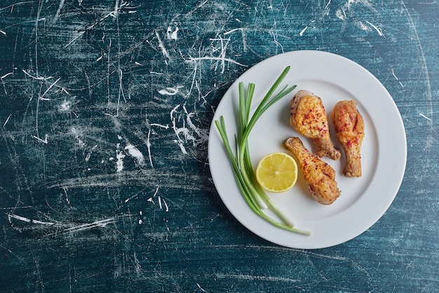 Gebratene Hähnchenschenkel mit Zitrone und Zwiebel.