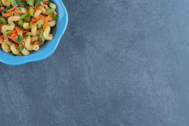 Kostenloses Foto gebratene hähnchenschenkel und nudeln auf holzstück.