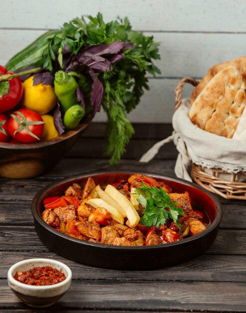 Gebratene Hähnchenstücke mit Tomaten, Pfeffer und Pommes Frites