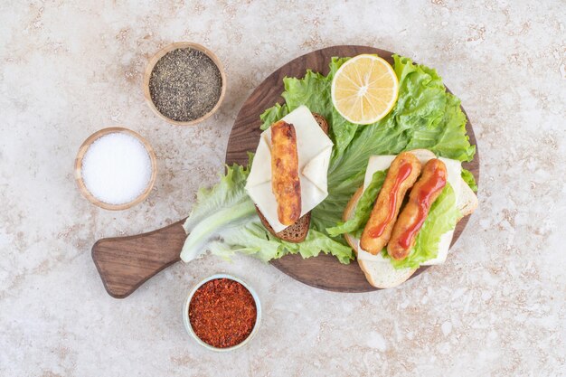 Gebratene Hühnernuggets und Käsesticks auf einem Holzbrett auf einem Stück Salatblatt.