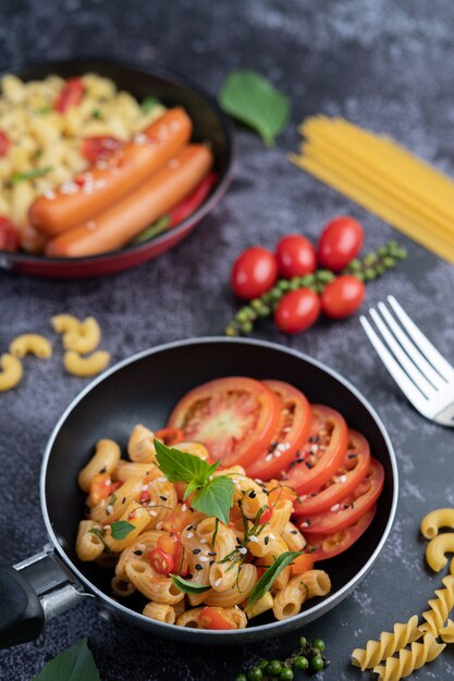 Gebratene Makkaroni und Wurst in einer Pfanne.