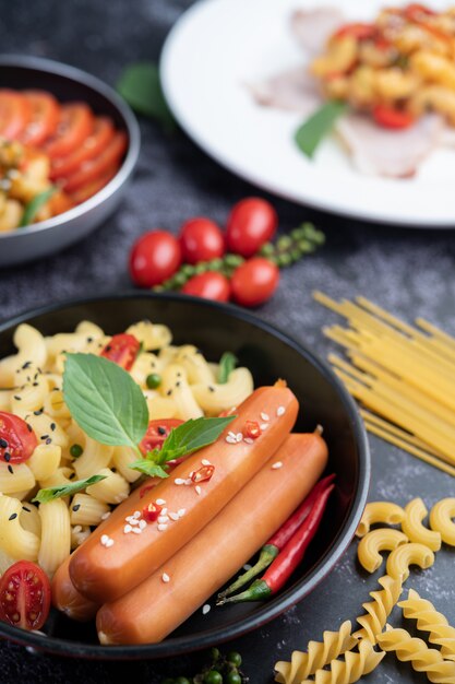 Gebratene Makkaroni und Wurst in einer Pfanne.