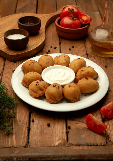 Gebratene Pelmeni-Knödel, serviert mit Joghurt