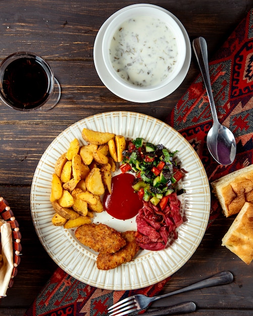 Gebratene Schnitzel und Kartoffeln mit Hirtensalat und Dovga