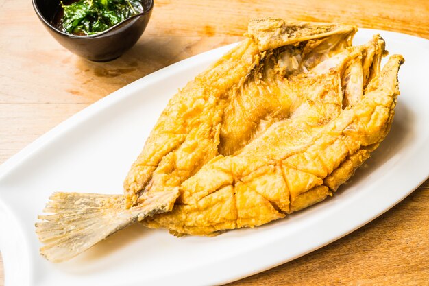 Gebratene Wolfsbarschfische in der weißen Platte mit würziger und süßer Soße