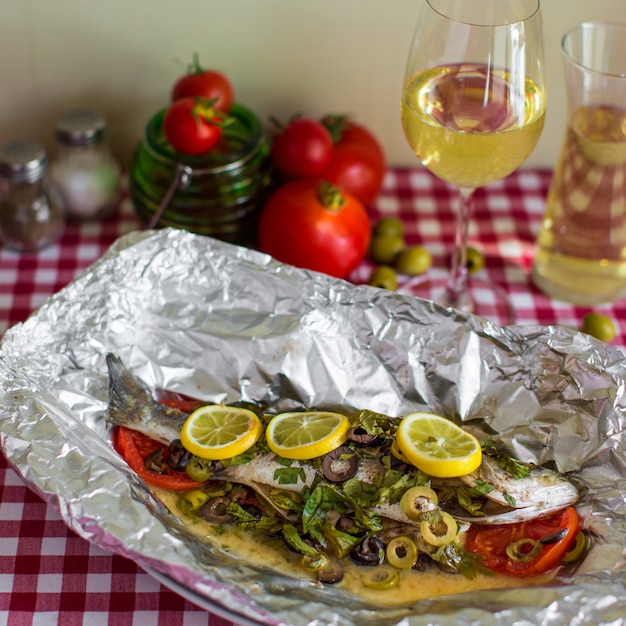 Gebratener Fisch mit Soße und Gemüse in Aluminiumfolie im Ofen gekocht