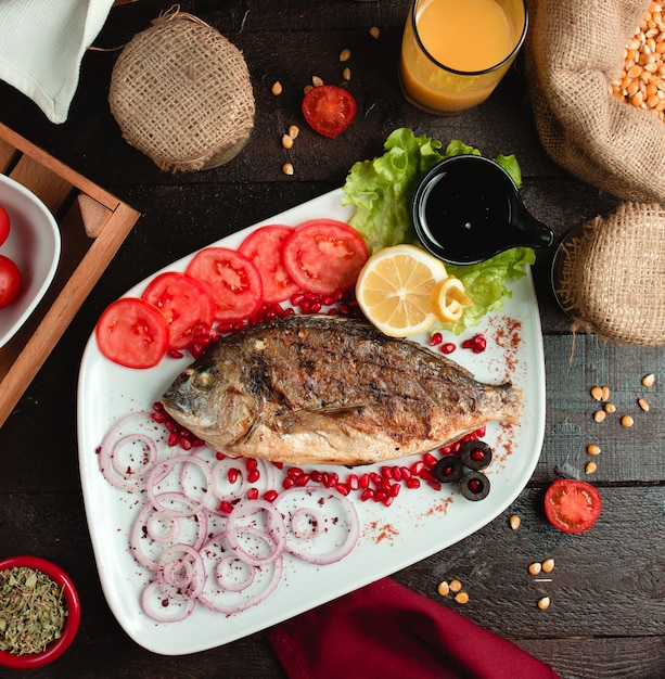 Gebratener Fisch mit Tomaten und Zwiebeln